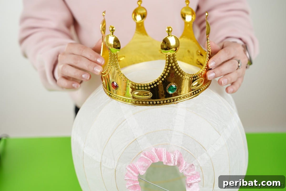 Enchanting Diaper Carriage Baby Shower Surprise 26 Fake crown being placed on top of white paper lantern