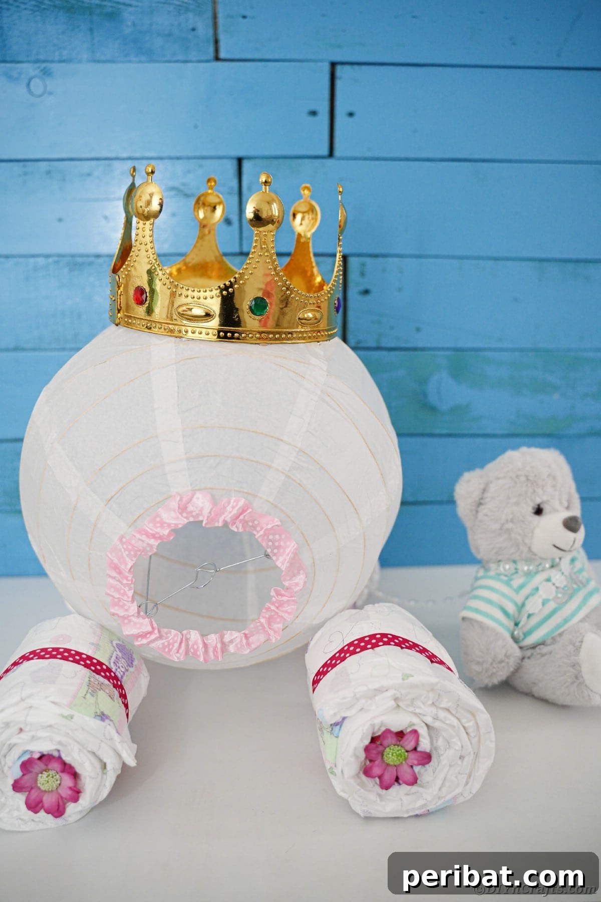 Enchanting Diaper Carriage Baby Shower Surprise 5 Diaper cake on white table by bear in front of blue wood background