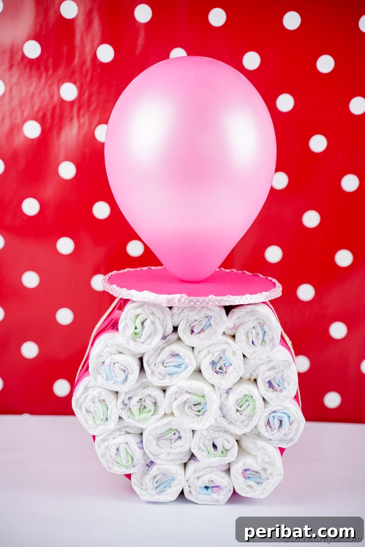 Craft Your Own Darling Pacifier Diaper Cake 14 Standing diaper cake pacifier in front of red and white wall