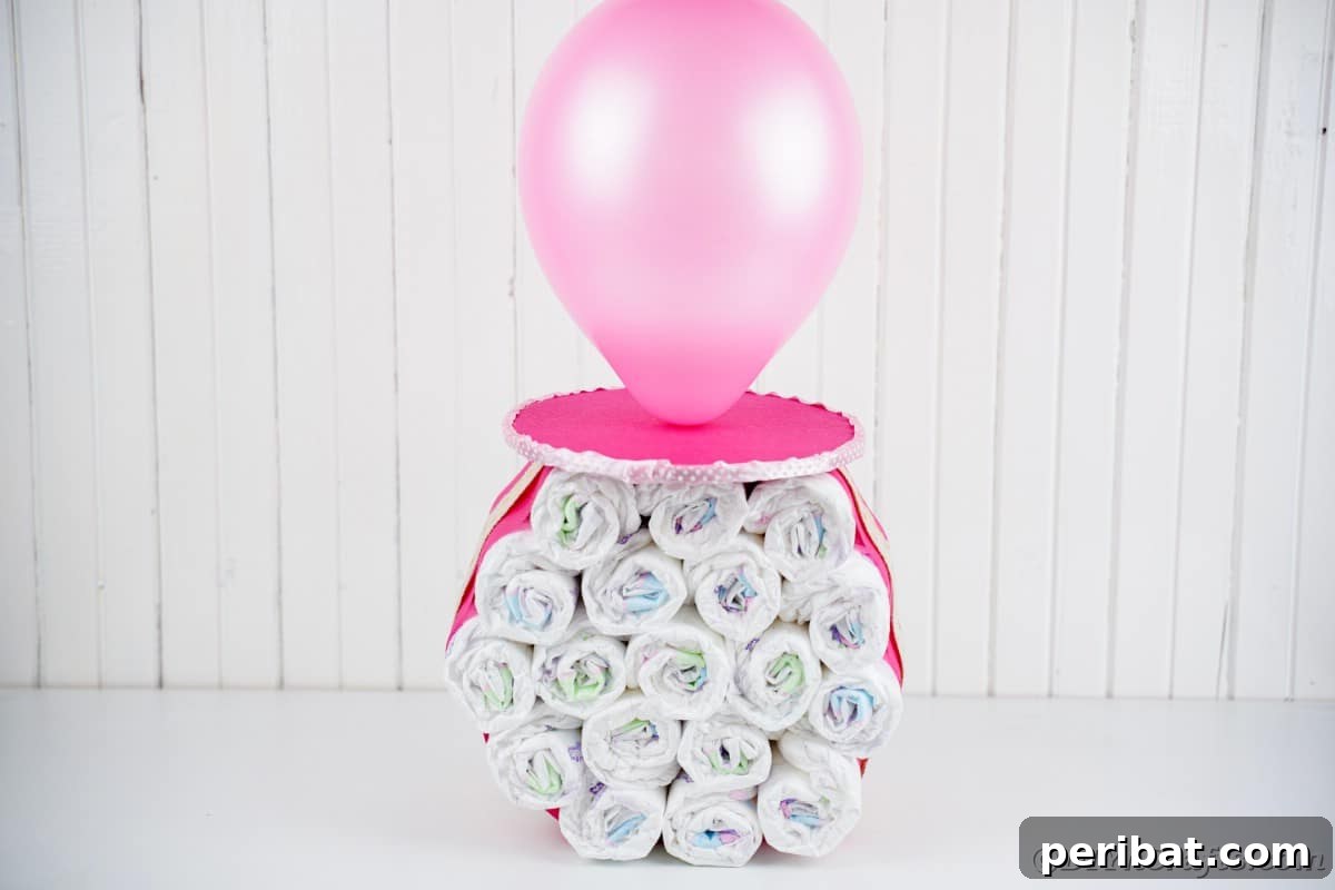 Craft Your Own Darling Pacifier Diaper Cake 4 Pink fake giant pacifier on white table