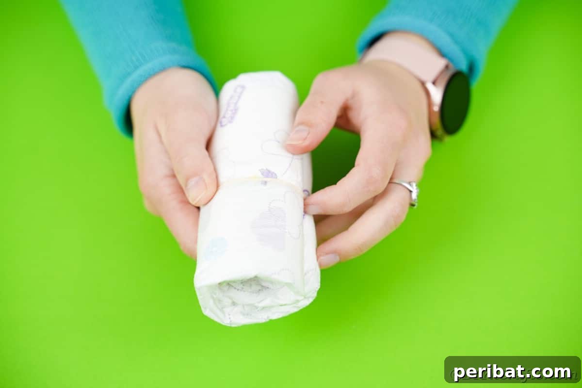 Craft Your Own Darling Pacifier Diaper Cake 7 Woman holding rolled diaper