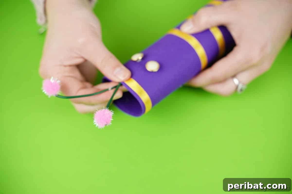 Fluttering Baby Delight: DIY Butterfly Diaper Cake 13 Securing the wire antennae to the top of the butterfly body with hot glue, completing the facial features of the diaper cake.