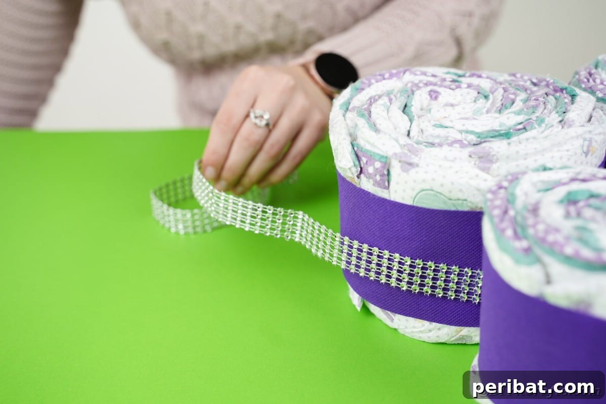 Fluttering Baby Delight: DIY Butterfly Diaper Cake 20 Gluing beaded ribbon around the outside of a completed butterfly diaper cake wing section.