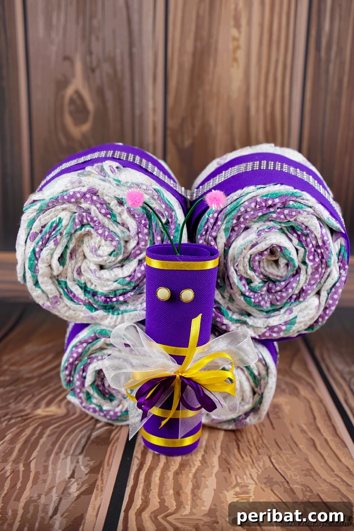 Fluttering Baby Delight: DIY Butterfly Diaper Cake 26 Diaper butterfly with a purple body and bright yellow accents, displayed as a creative and colorful baby gift.