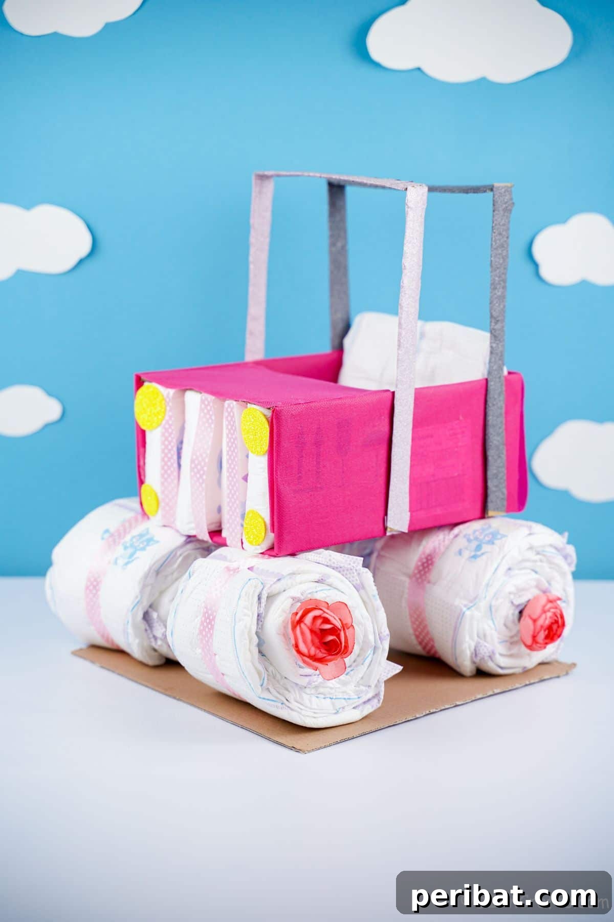 pink safari car diaper cake on white table with blue cloudy background