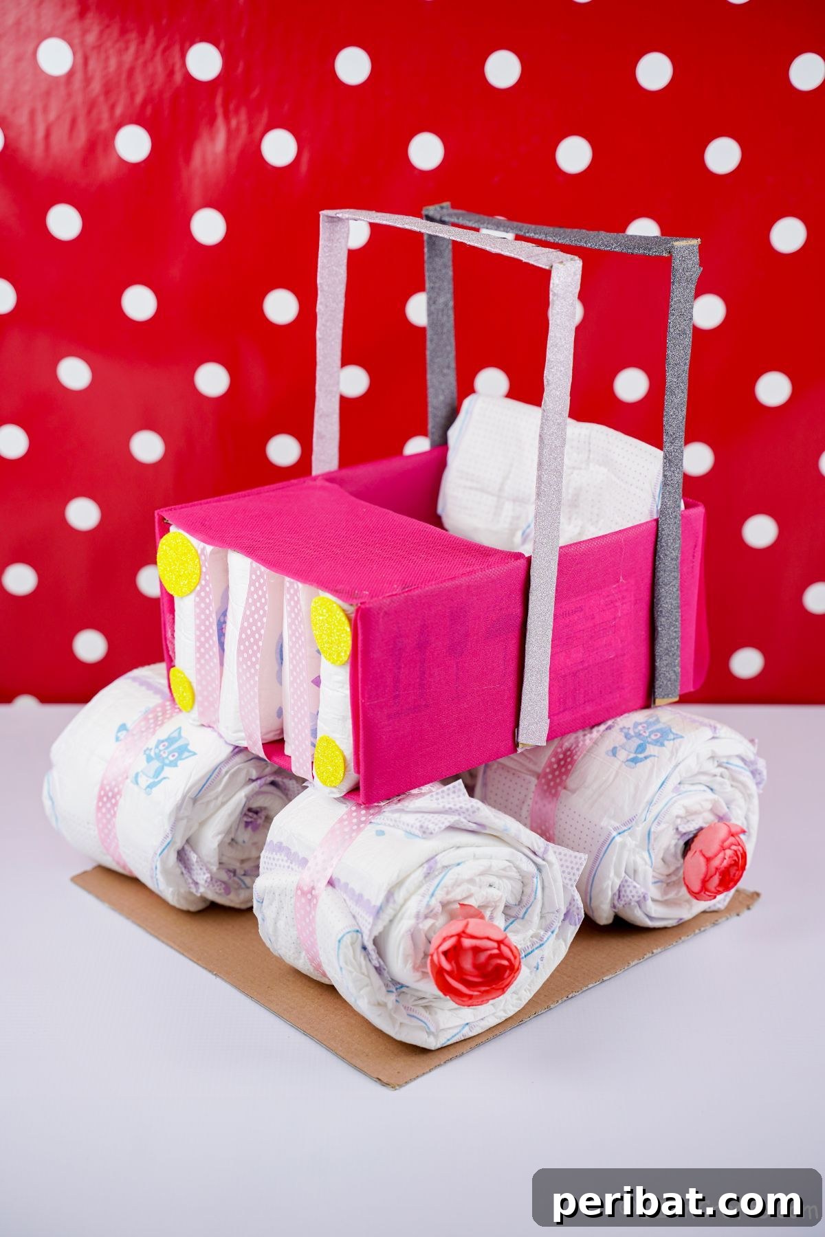 pink safari car diaper cake with red and white polka dot background