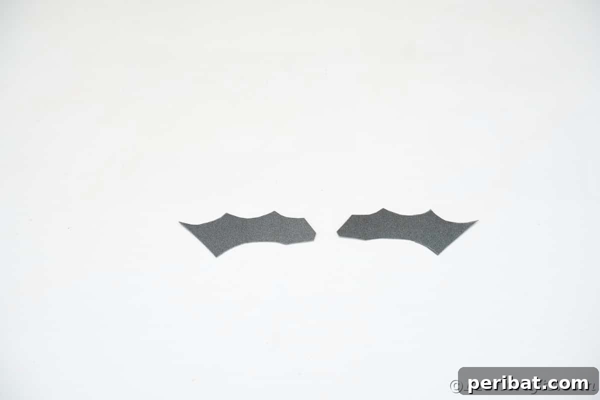 Black bat wing paper shape on white table
