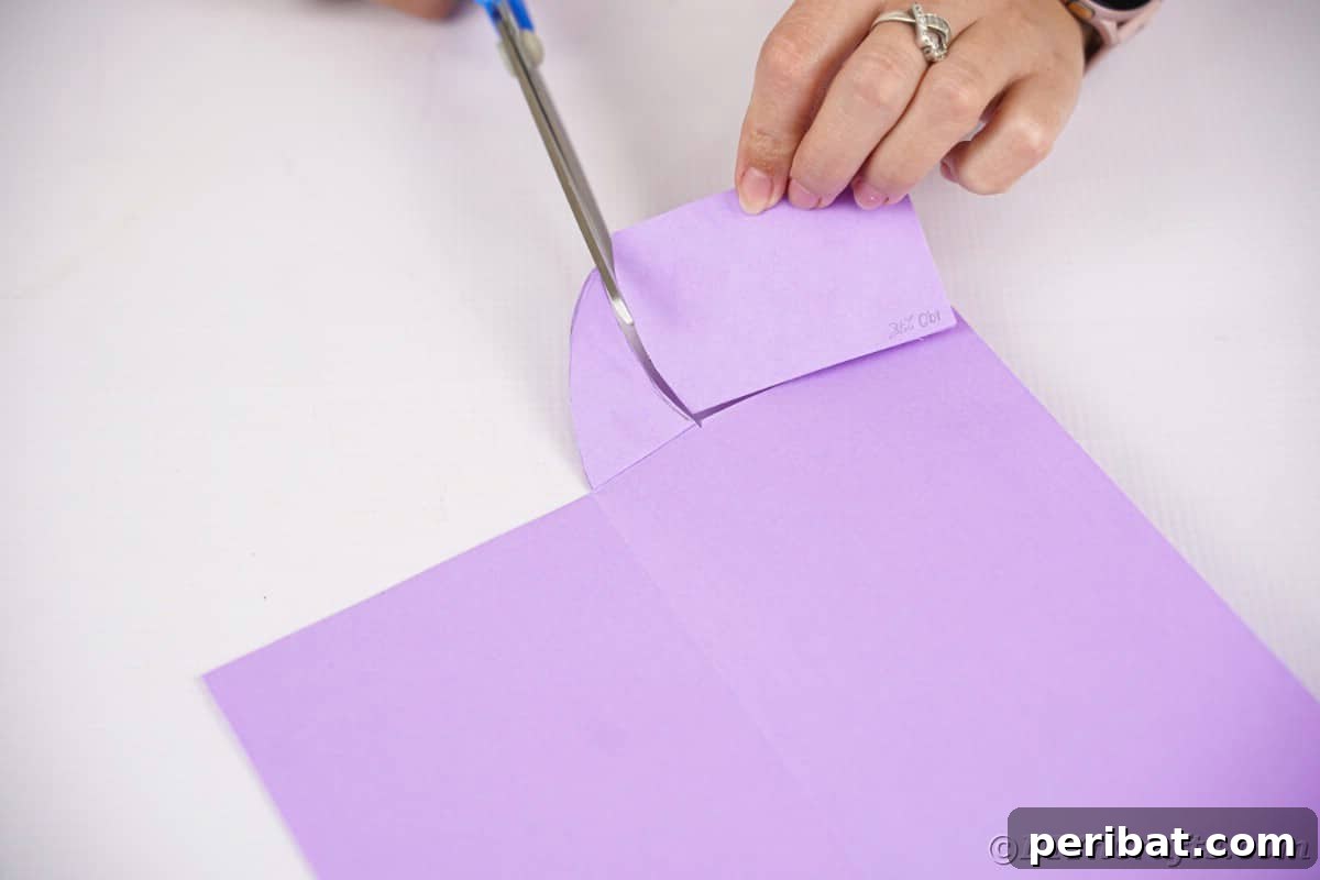 Fan-tastic Hedgehog Craft for Kids 13 A hand using scissors to precisely cut the hedgehog's head shape from the purple paper, detailing the final contour.