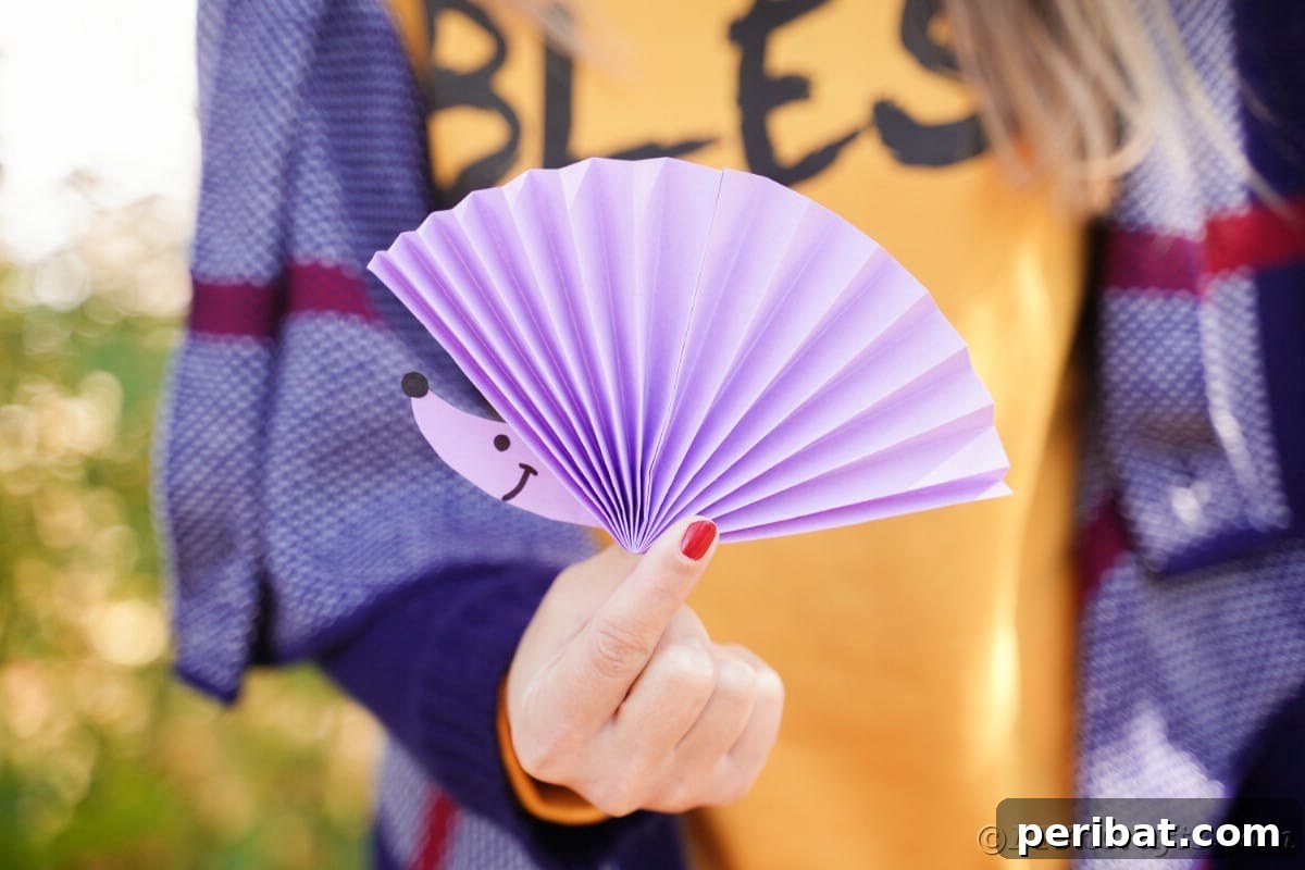 Fan-tastic Hedgehog Craft for Kids 25 Woman in orange holding up paper fan with hedgehog face