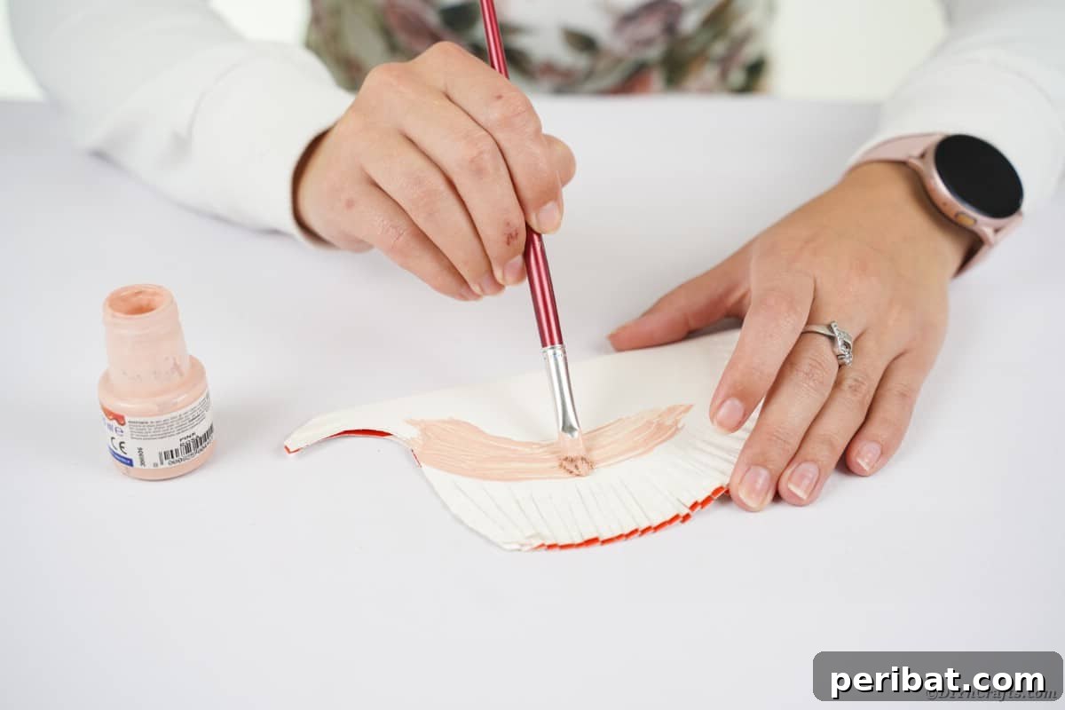 Hand painting paper plate with tan paint