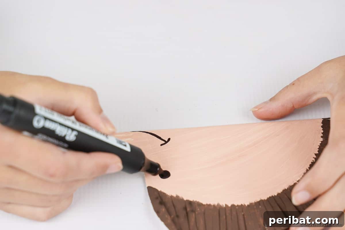 Hand drawing eyes and mouth onto paper plate hedgehog