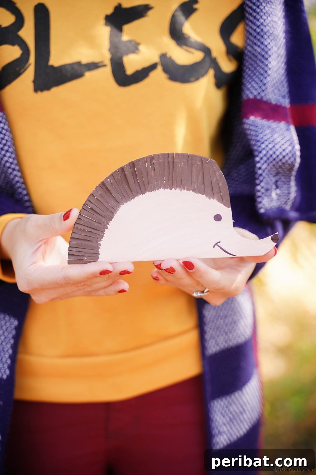Woman in orange shirt holding a paper plate hedgehog