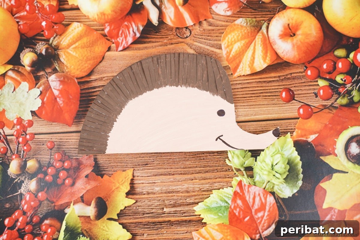 Fake leaves and paper hedgehog on wood table