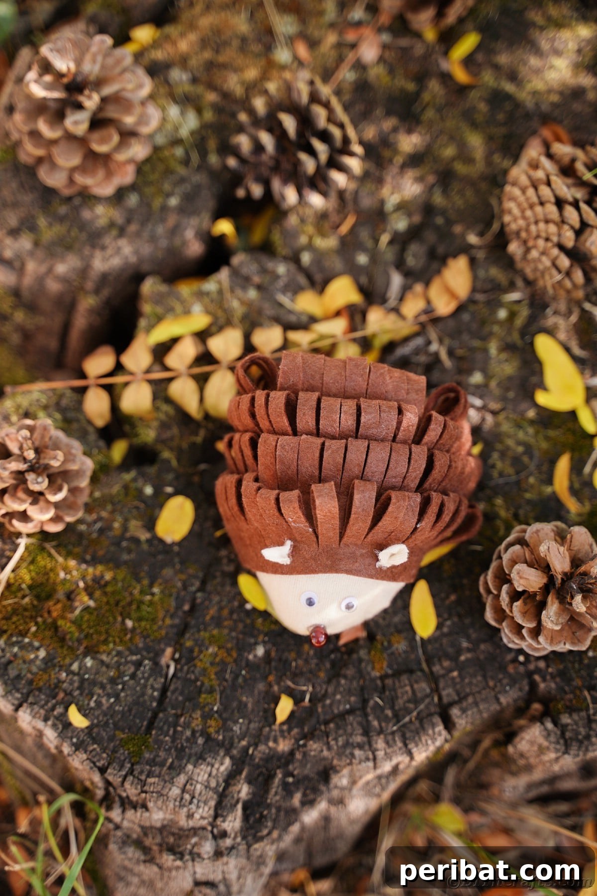 Effortless No-Stitch Fabric Hedgehog Creation 5 An overhead view captures the intricate details of a no-sew fabric hedgehog, showcasing its textured 'spikes' and rounded body on a rustic tree stump.