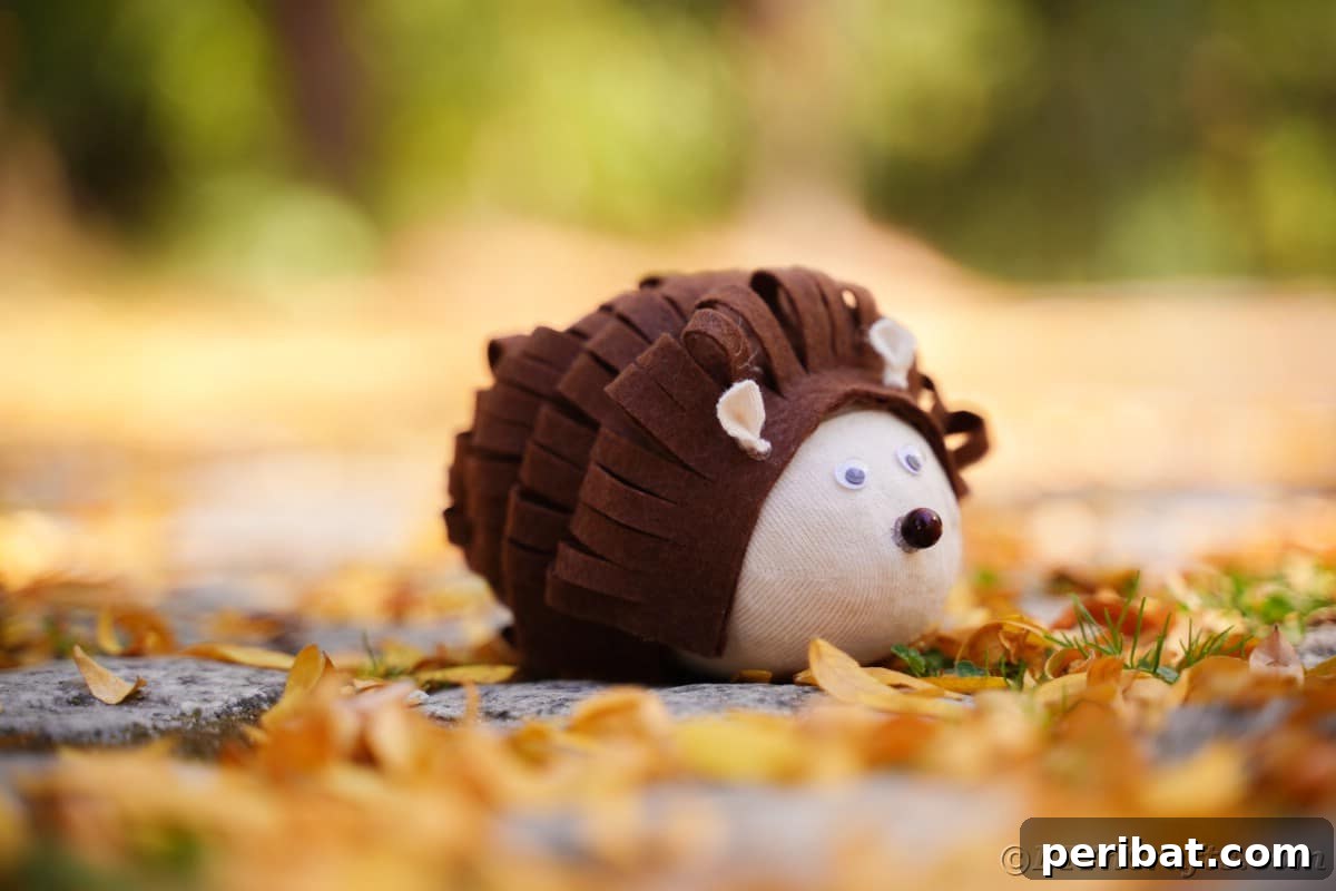Effortless No-Stitch Fabric Hedgehog Creation 6 A charming brown felt hedgehog sits gracefully amidst a bed of golden yellow leaves, showcasing its texture and woodland charm.