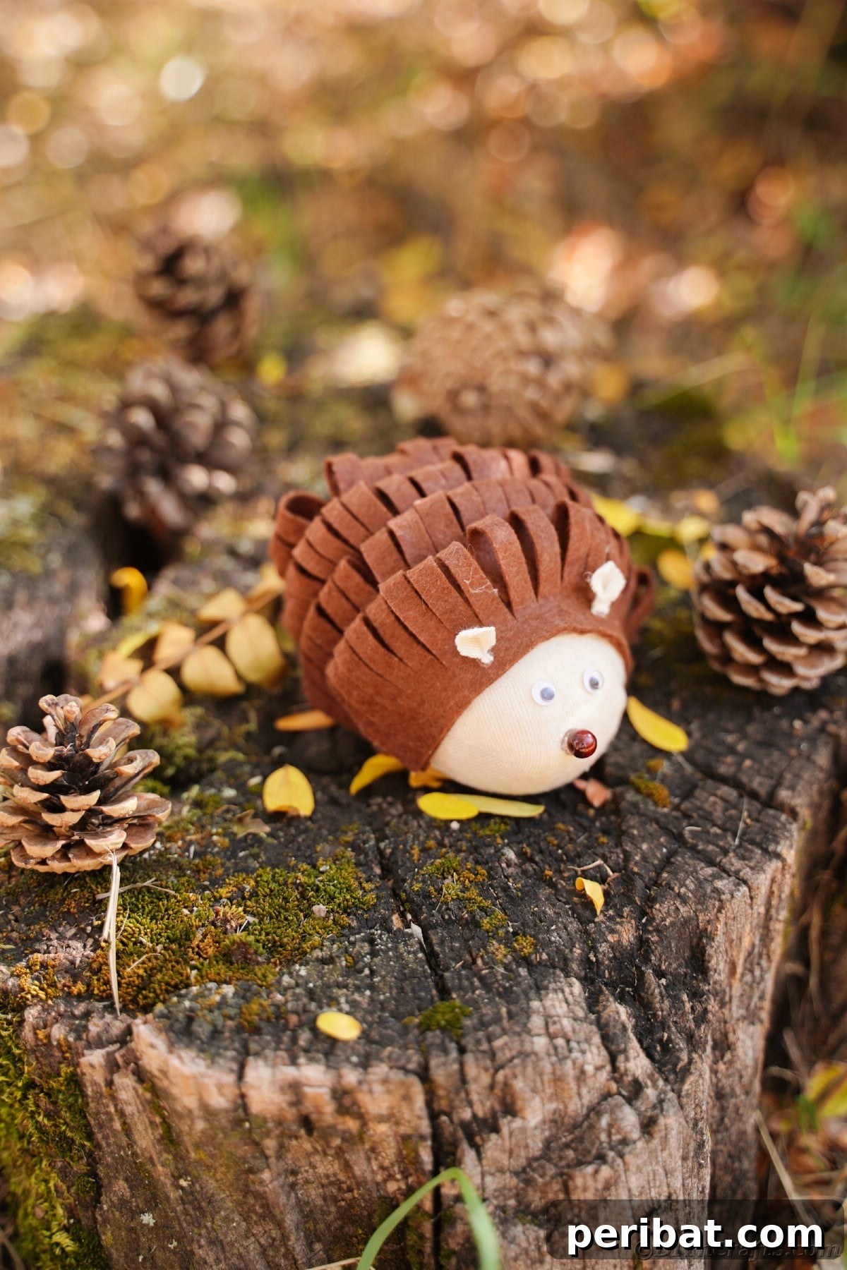 Effortless No-Stitch Fabric Hedgehog Creation 7 A charming brown and tan toy critter, likely a hedgehog, sits amidst natural elements like a tree stump and pinecones, exuding rustic appeal.