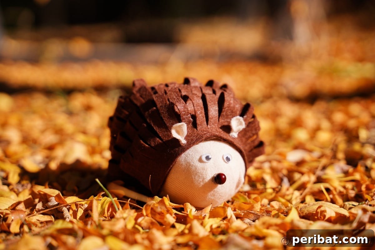 Effortless No-Stitch Fabric Hedgehog Creation 8 A charming fabric hedgehog rests peacefully on a scattered pile of autumn leaves, emphasizing its natural aesthetic and seasonal charm.