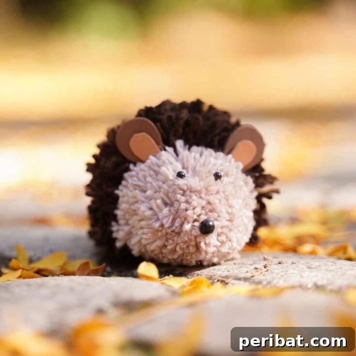 Adorable Pom Pom Hedgehog Fall Craft for Kids 11 A charming toy hedgehog sits on a rock, amidst vibrant autumn leaves