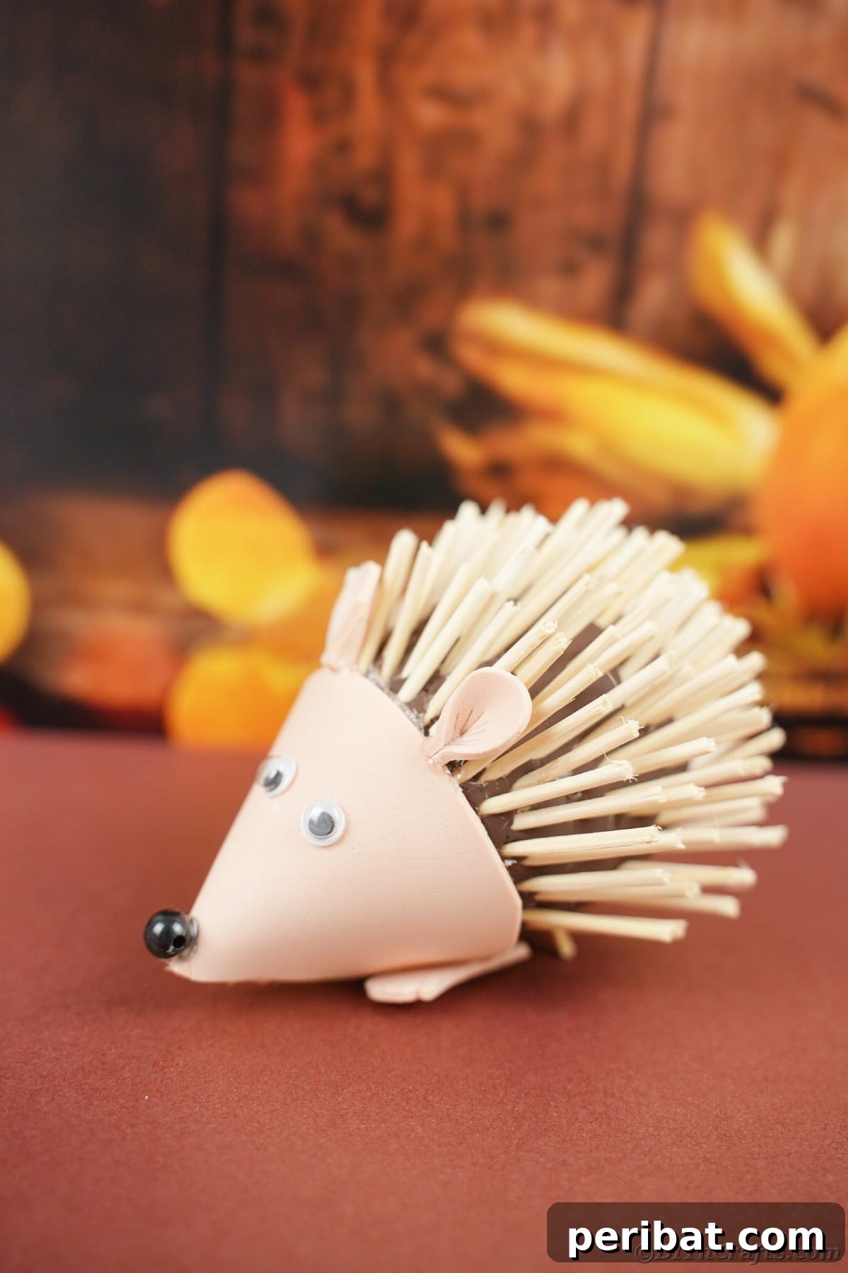Rustic Foam Hedgehog: An Easy Autumn Craft for Kids 2 Mini hedgehog toy on brown table in front of fall scene