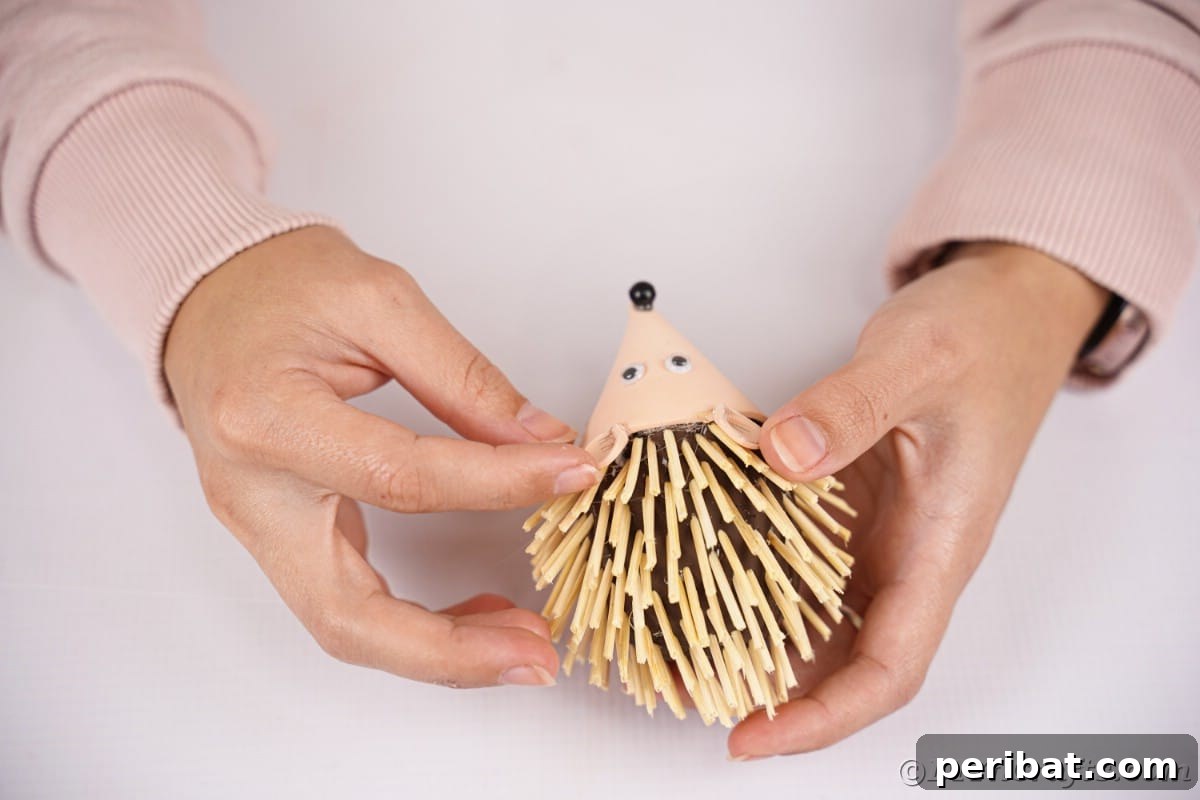 Rustic Foam Hedgehog: An Easy Autumn Craft for Kids 17 Hand holding ears in place on foam hedgehog
