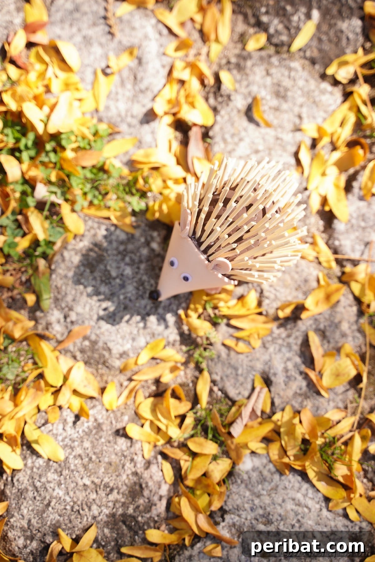 Rustic Foam Hedgehog: An Easy Autumn Craft for Kids 8 Foam hedgehog laying on cobblestone and yellow leaves