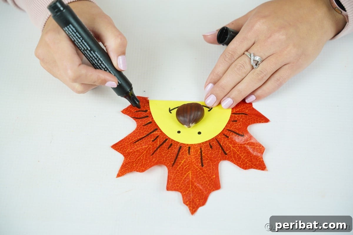 Hand drawing lines with black marker around yellow face on leaf