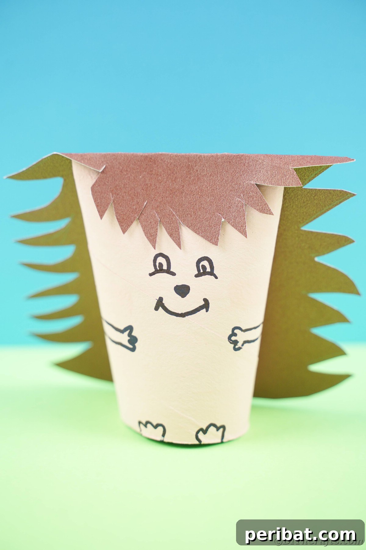 Charming Toilet Paper Roll Hedgehogs for Autumn 24 Mini paper hedgehog on green paper with blue background