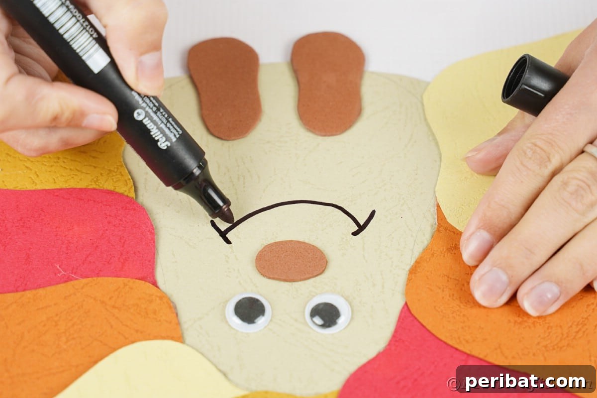 A hand using a black marker to draw a joyful smile onto the paper hedgehog's face