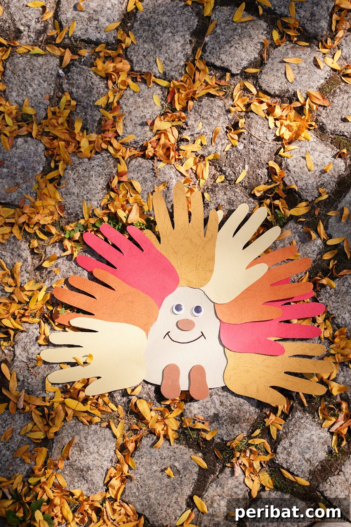 A delightful handprint hedgehog craft surrounded by vibrant yellow autumn leaves, resting on a rocky surface