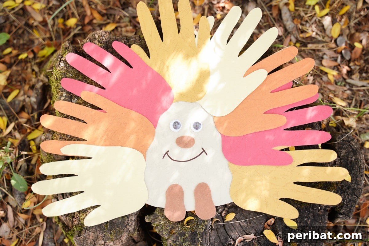 Finished handprint hedgehog craft beautifully displayed on a wooden tree stump outdoors