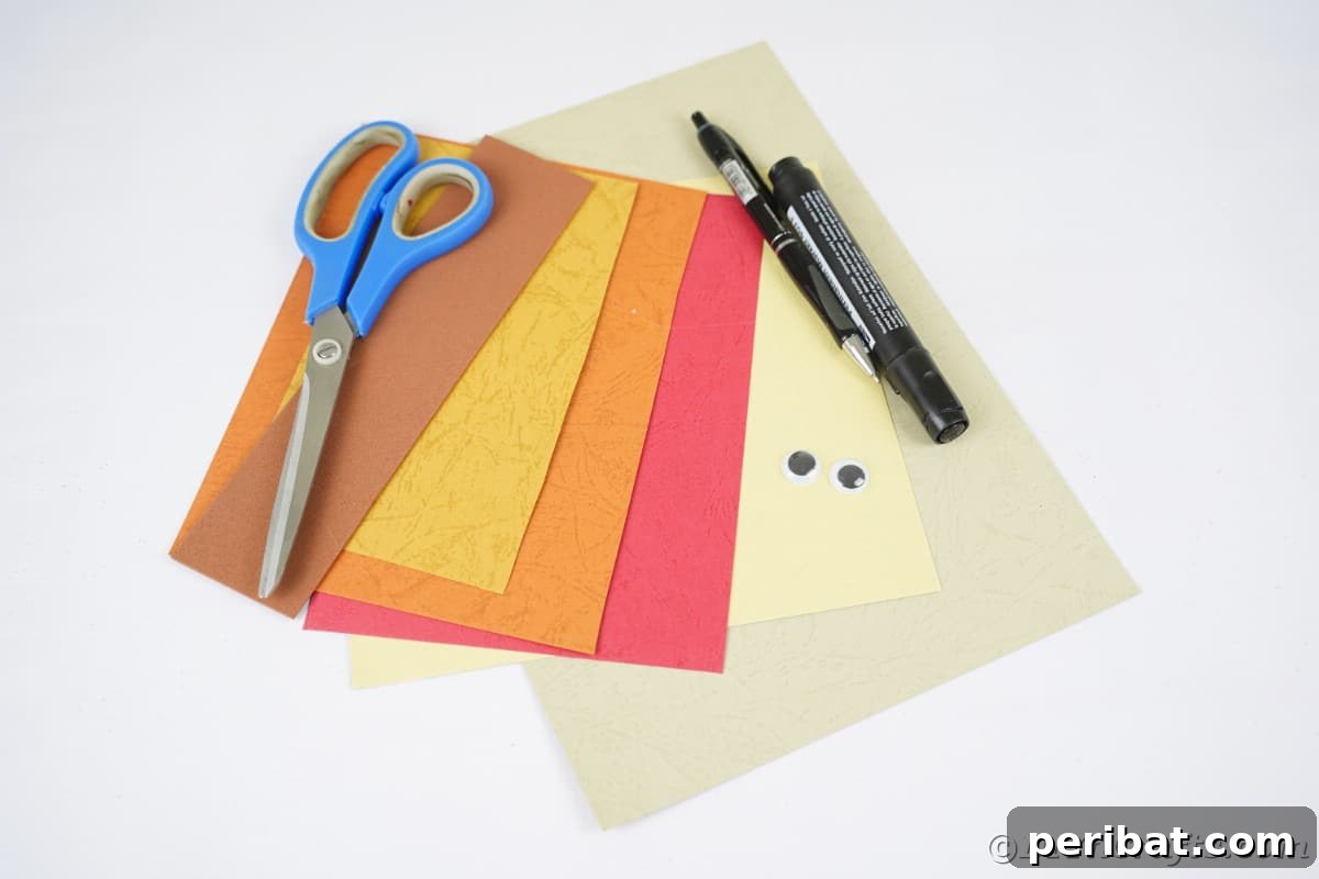 Craft papers in various autumnal shades, along with scissors and pens, neatly arranged on a white crafting table