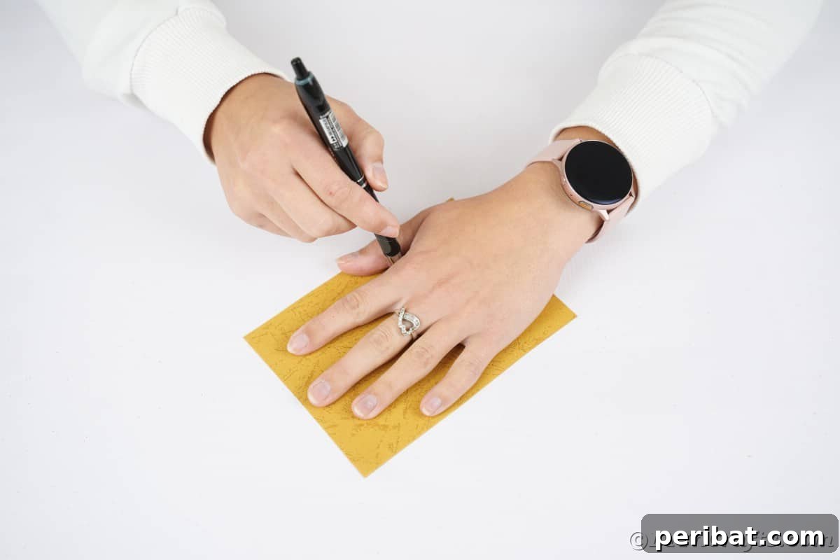 A child's hand tracing onto orange craft paper, ready to be cut out