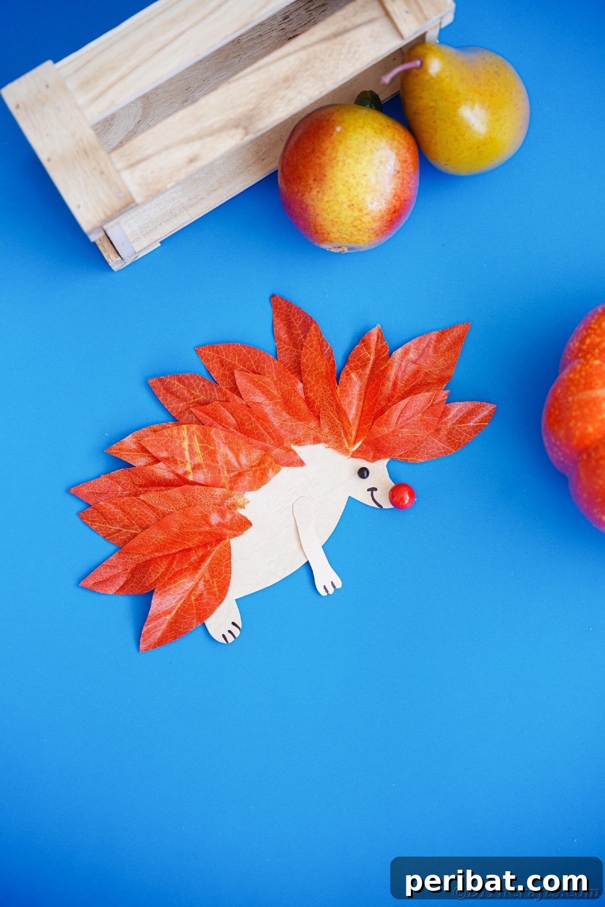 Mini paper hedgehog on blue table, showcasing a simple yet charming design.