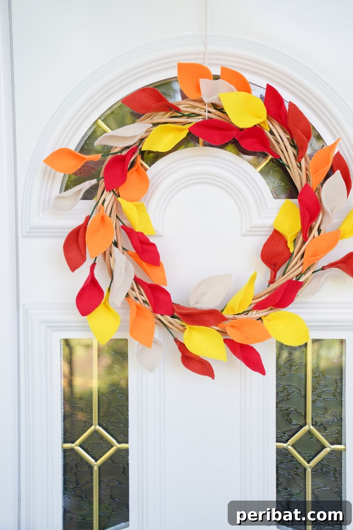 Fall wreath hanging on white door with glass insets