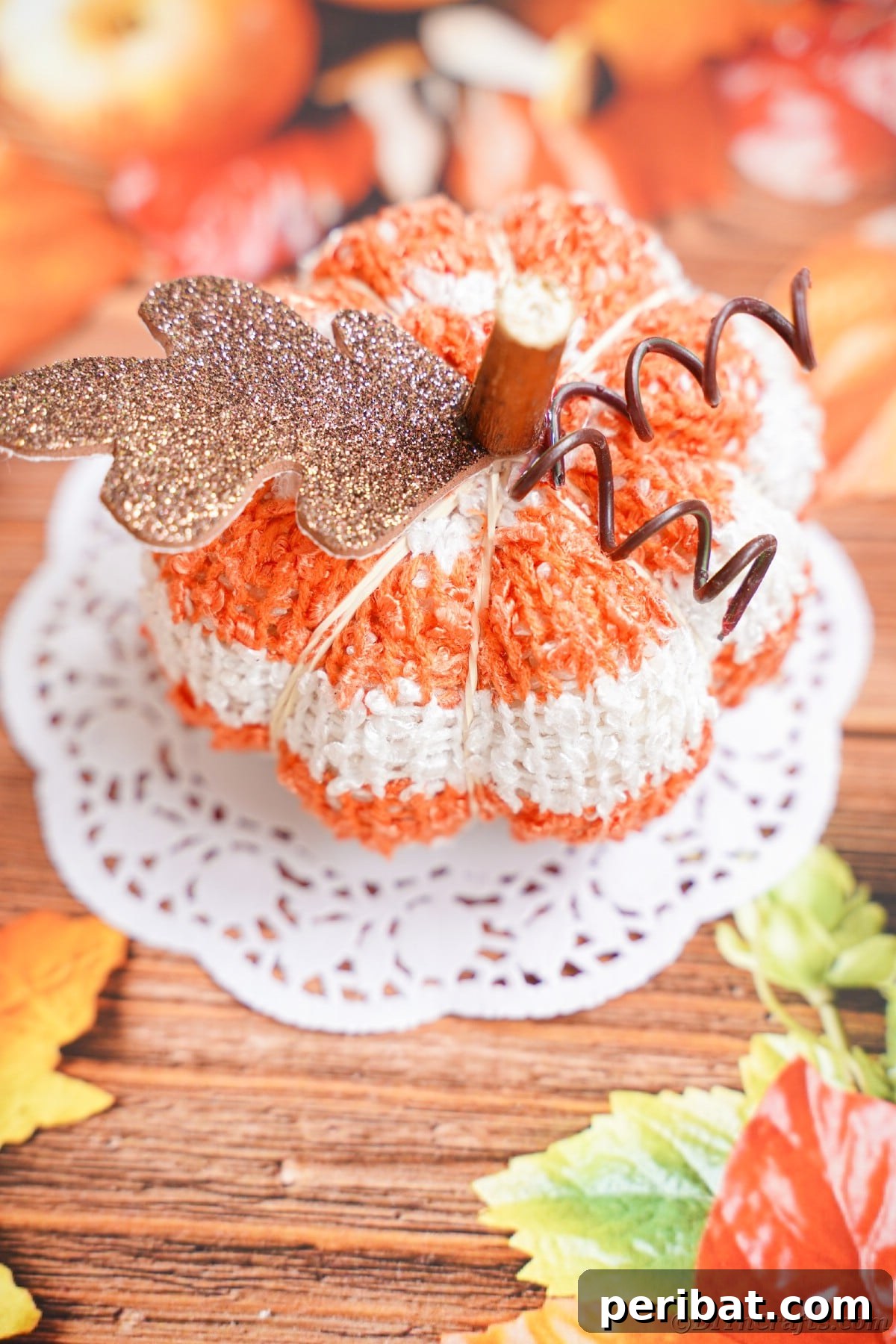Cozy Sock Pumpkins Fall Home Decor 2 Seasonal paper topped with white doily and striped pumpkin, evoking cozy fall vibes