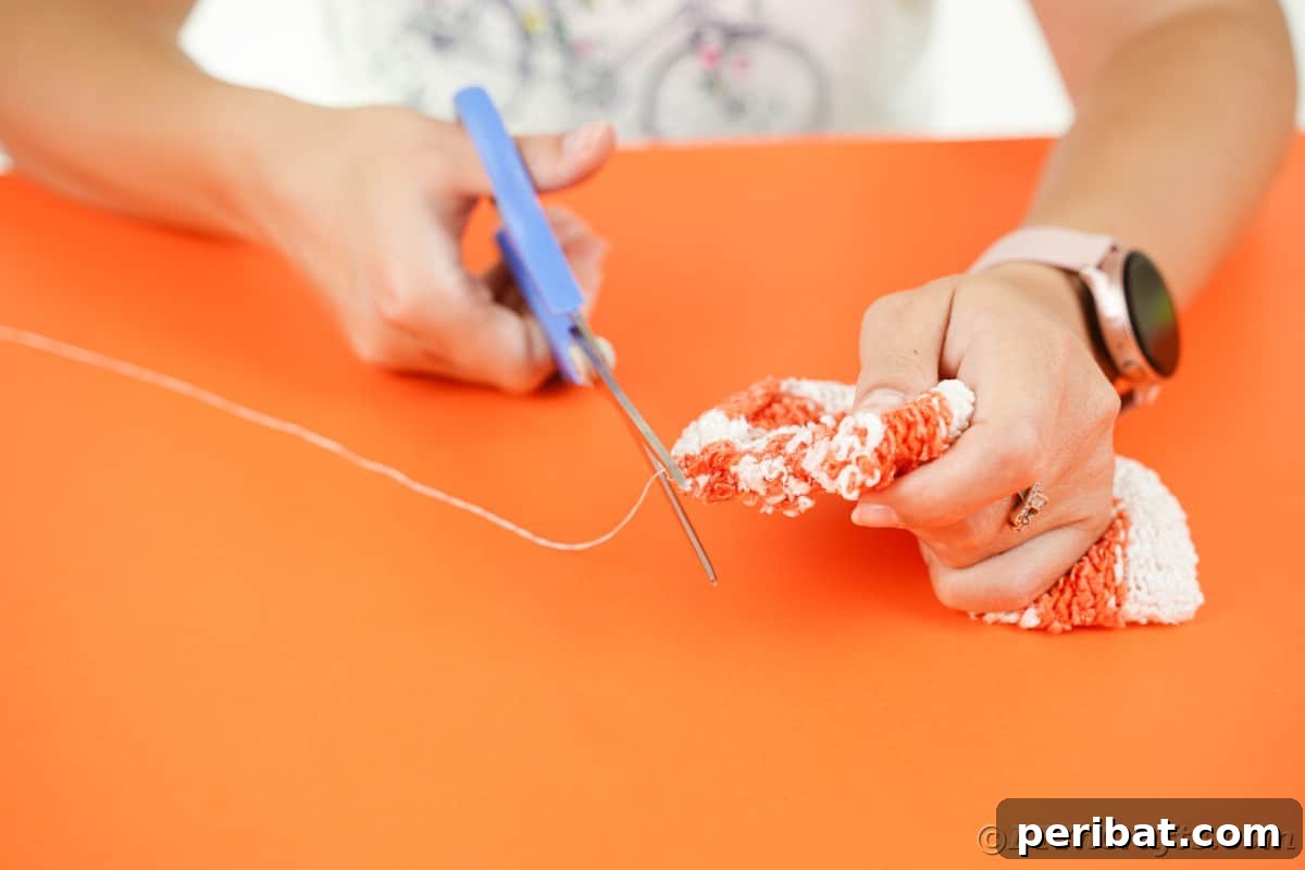 Cozy Sock Pumpkins Fall Home Decor 11 Hand cutting thread with blue scissors, a crucial step after sewing the sleeve