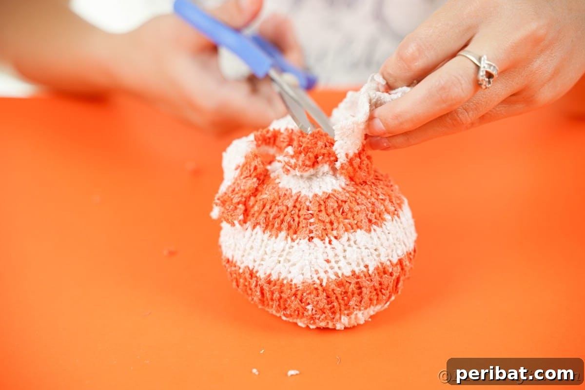 Cozy Sock Pumpkins Fall Home Decor 14 Blue scissors cutting extra fabric off top of sock, refining the pumpkin's shape