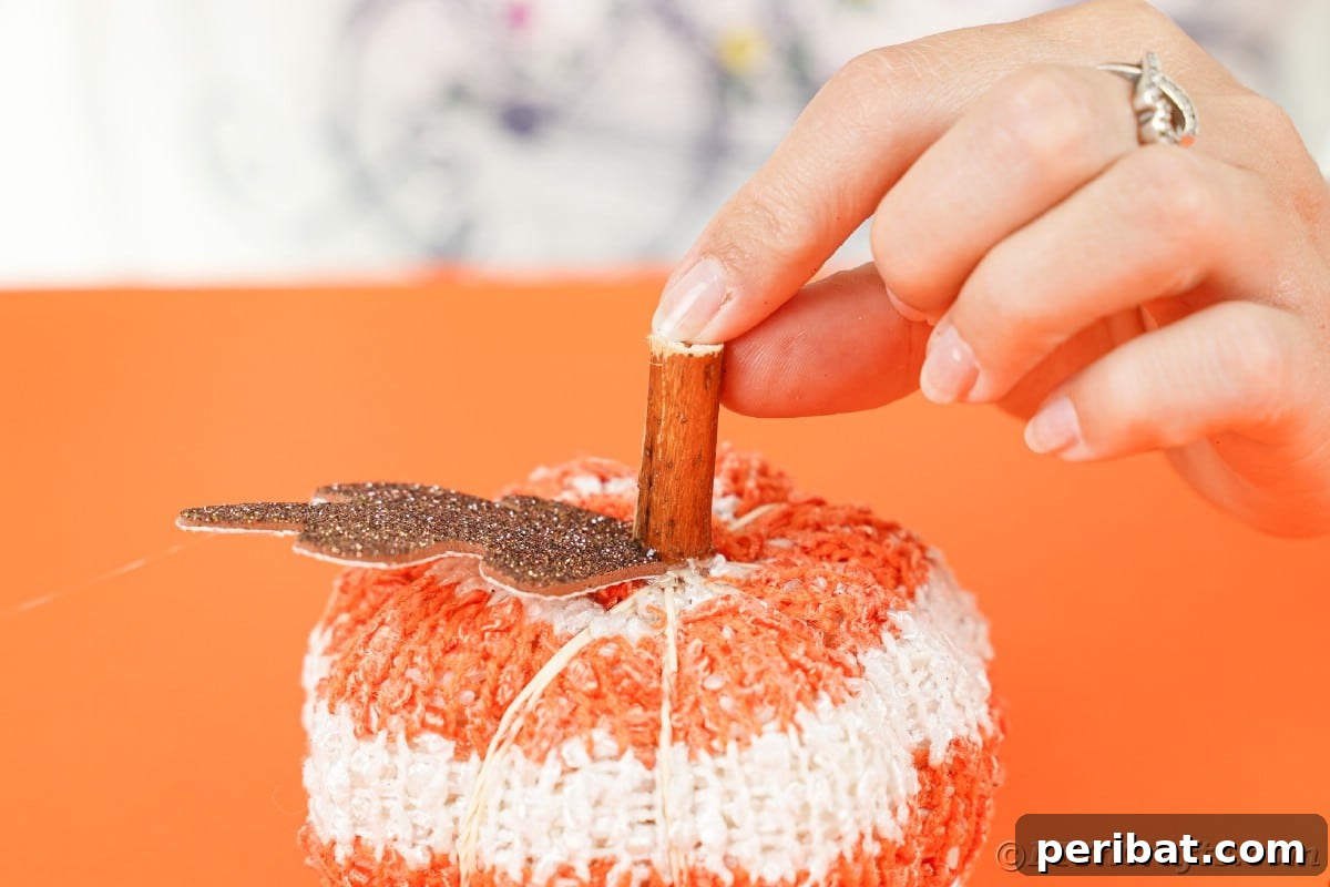 Cozy Sock Pumpkins Fall Home Decor 17 Gluing stick to top of pumpkin, securing the natural stem in place