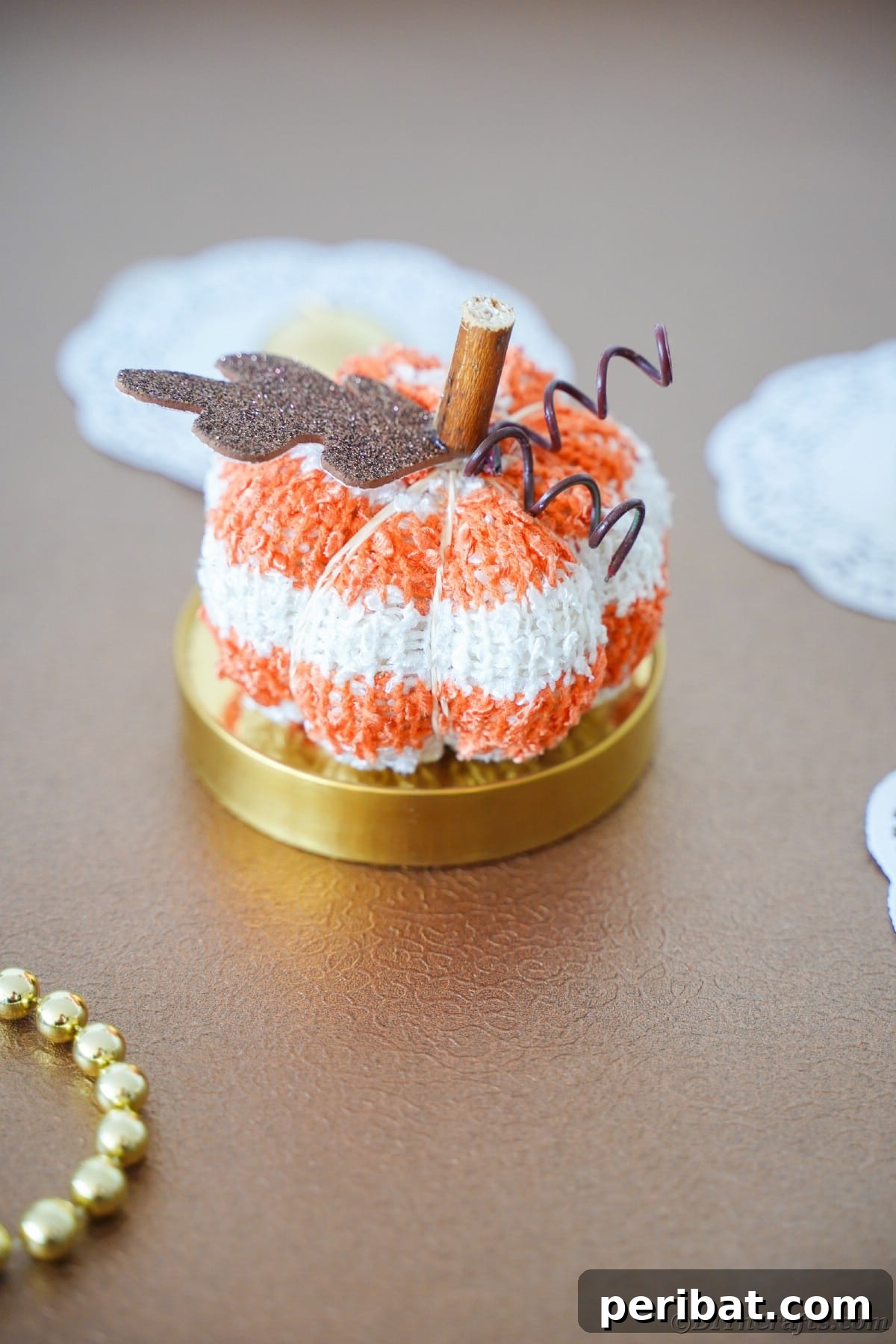 Cozy Sock Pumpkins Fall Home Decor 23 Stuffed sock pumpkin on gold surface, highlighting its elegant side with metallic accents