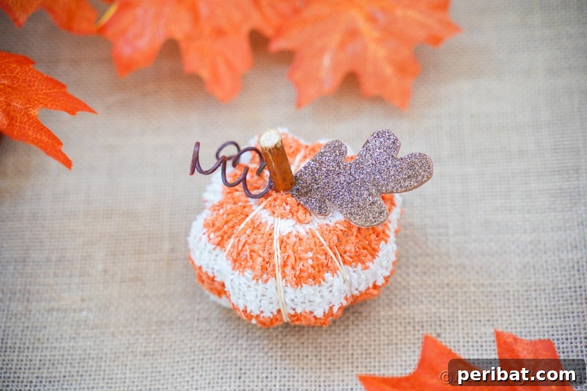 Cozy Sock Pumpkins Fall Home Decor 6 Fabric pumpkin on brown table with fake leaves, creating an inviting autumn display