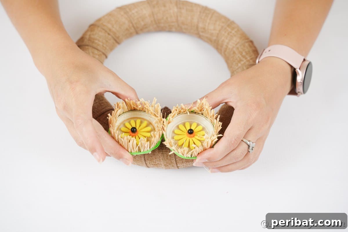 Farmhouse Burlap Owl Wreath 18 Hands gluing eyes to owl wreath, completing the facial features of the DIY owl decor