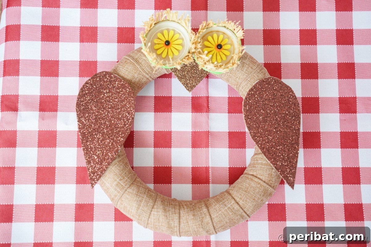 Farmhouse Burlap Owl Wreath 3 Rustic wreath looking like an owl on red and white table, highlighting the handmade charm of the burlap owl design