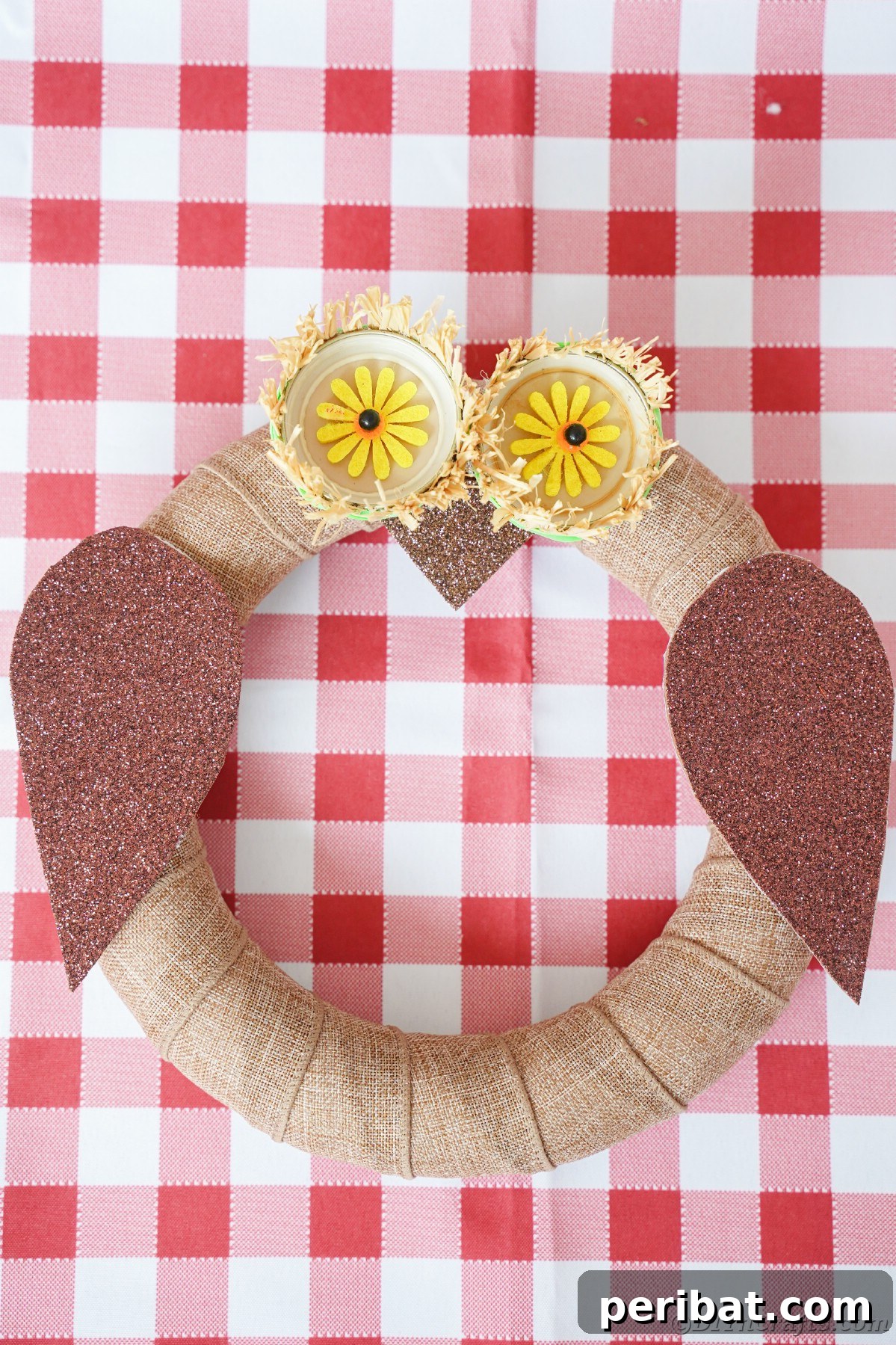 Farmhouse Burlap Owl Wreath 22 Owl wreath laying on red checked tabelcloth, showcasing a different angle of the rustic owl decor