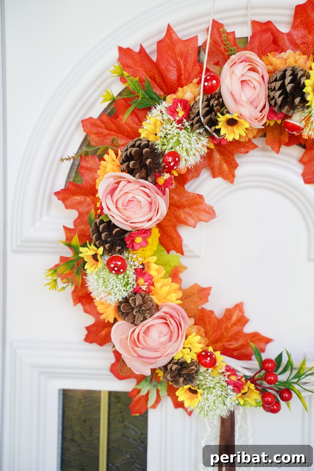 Charming Fall Blossom & Pinecone Wreath 15 Close up picture of floral and fall leaf wreath on white door