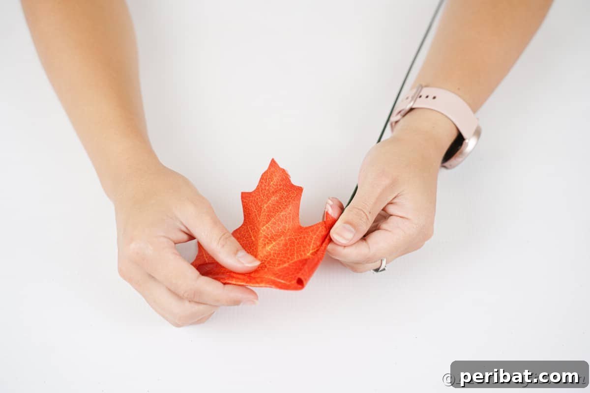 Elegant Autumn Rose Displays Crafted from Faux Foliage 9 Hand rolling orange leaf over floral wire