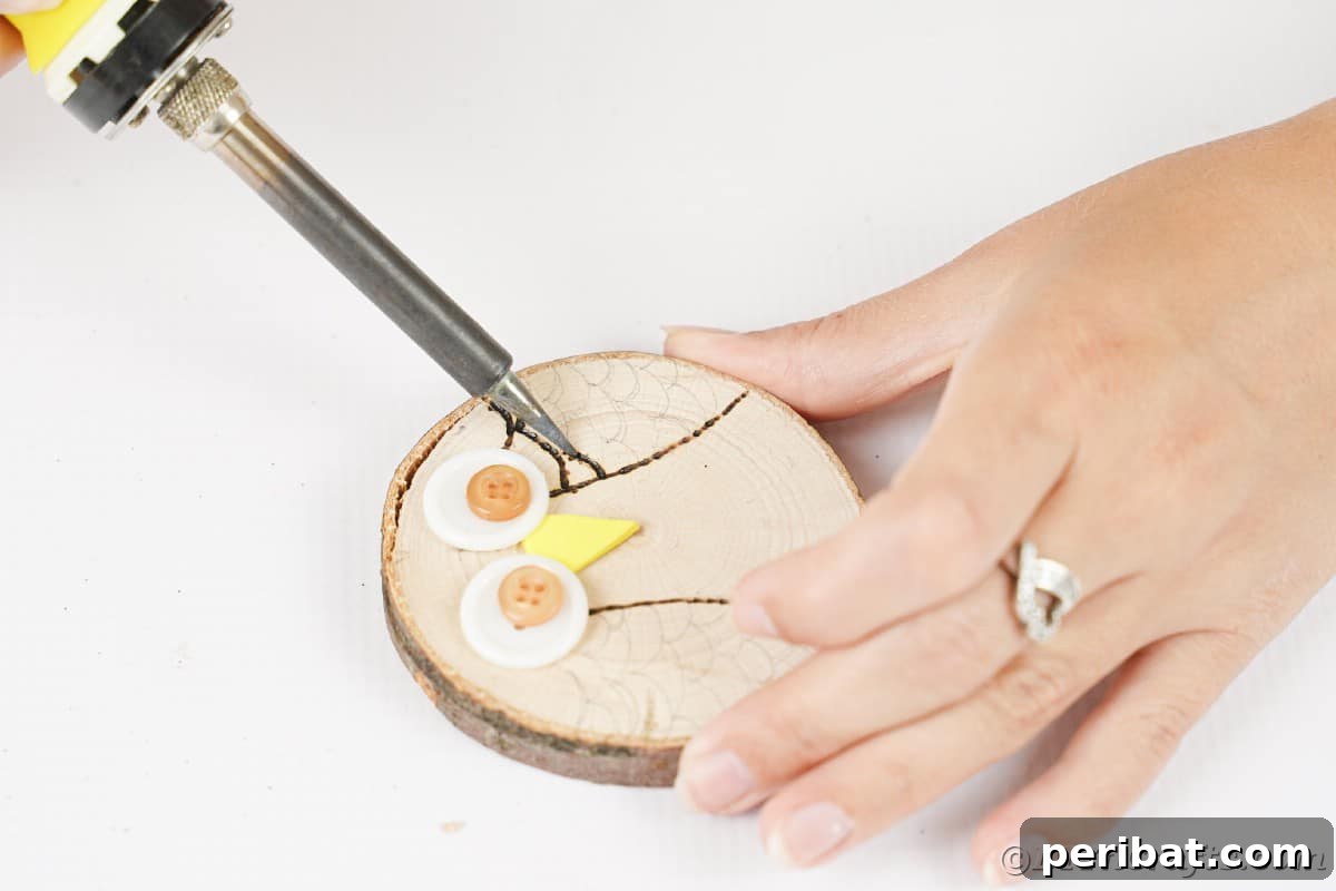 A wood burning tool skillfully creates intricate owl wings on a wood slice, leaving behind dark, textured lines that bring the design to life.
