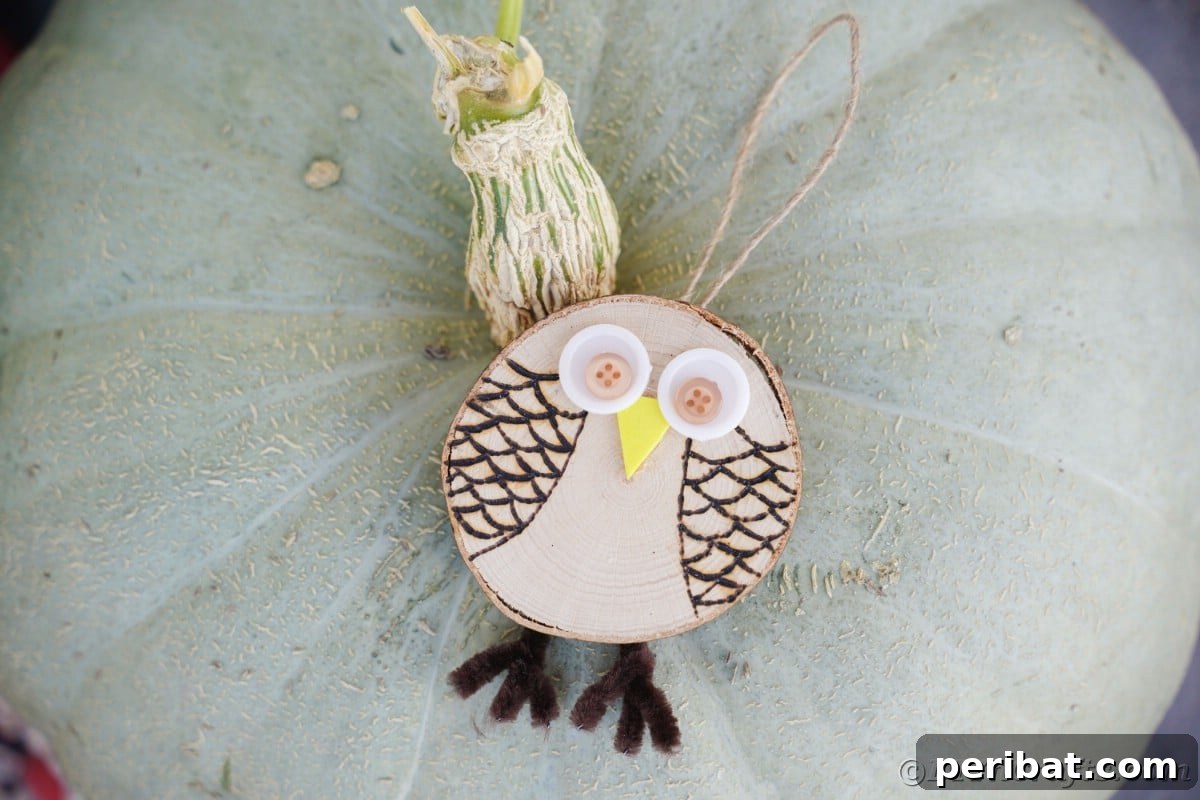 A charming wood owl ornament rests playfully on top of a vibrant green pumpkin, creating a whimsical and festive seasonal display.