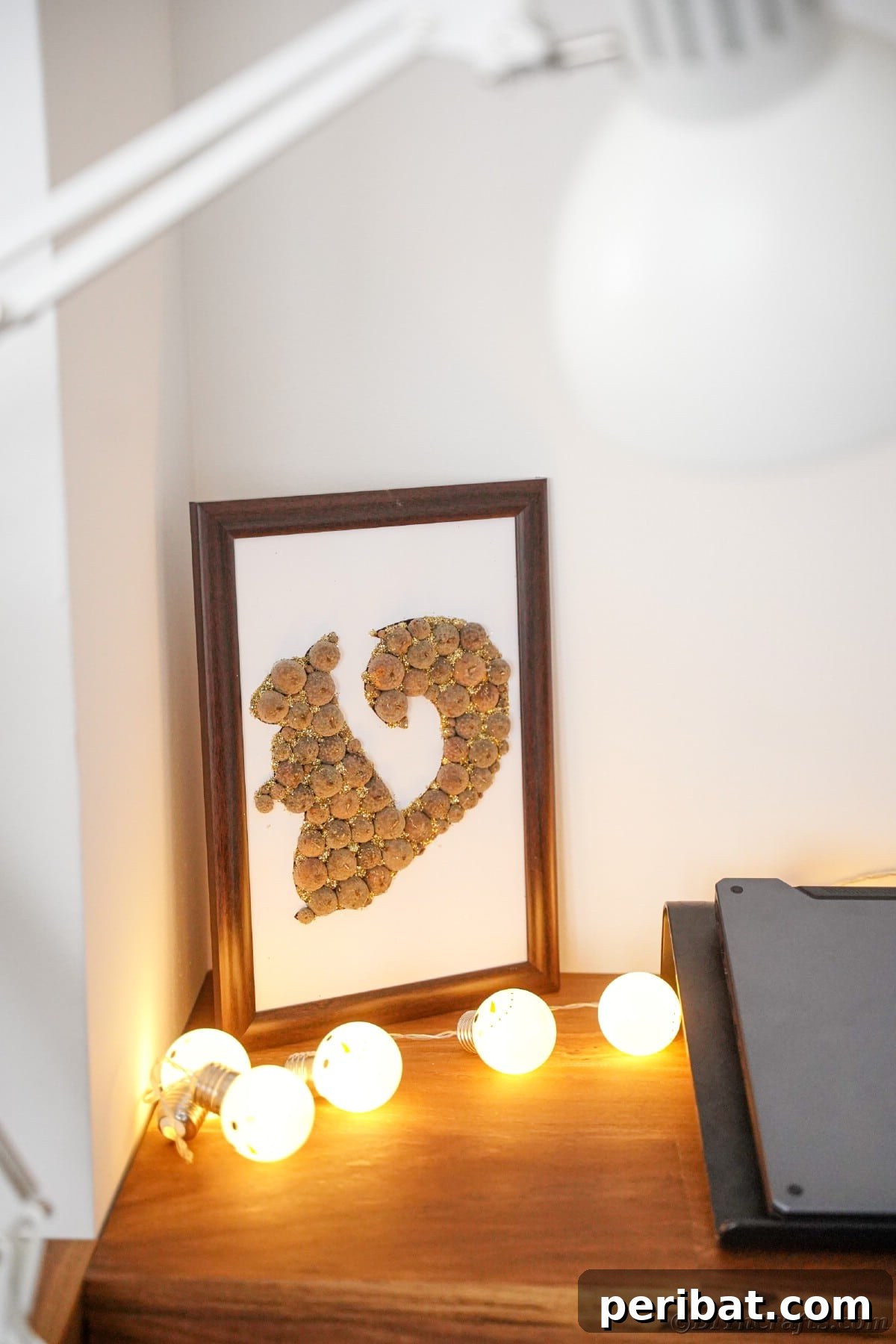 Charming Framed Squirrel with Acorn Cap Wall Decor 2 Acorn cap squirrel framed and sitting on table with string of bulb lights
