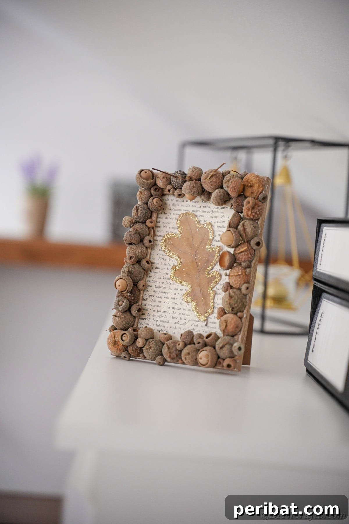 Acorn cap picture frame on a white shelf, emphasizing the rustic and natural elements of the fall craft.
