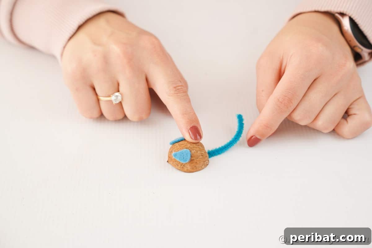 Walnut Wonders: Upcycled Shell Mouse Art 15 Hand holding down walnut shell mouse